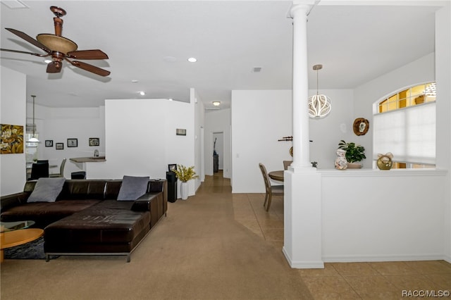 living room featuring light tile patterned floors, decorative columns, and ceiling fan