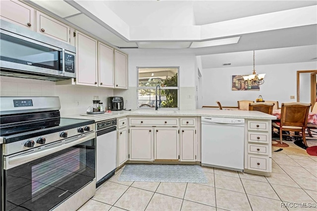 kitchen featuring light tile patterned flooring, sink, a chandelier, pendant lighting, and stainless steel appliances