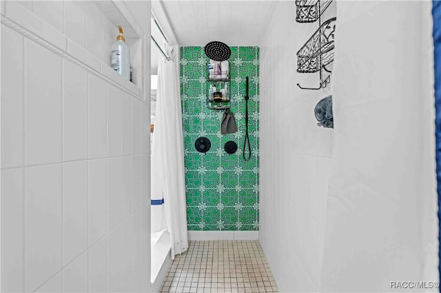 bathroom with tile walls, tile patterned floors, and curtained shower