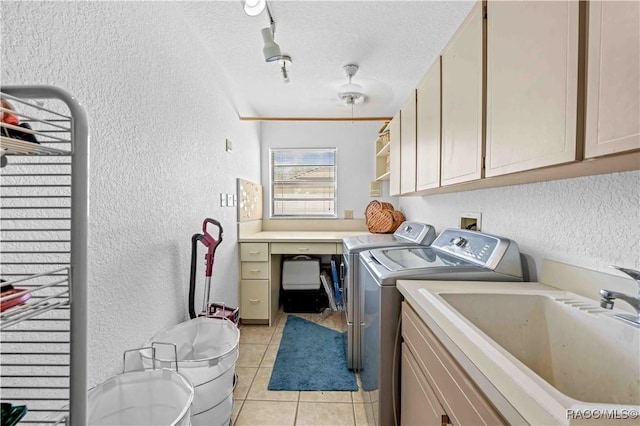 washroom with washing machine and clothes dryer, sink, cabinets, a textured ceiling, and light tile patterned floors