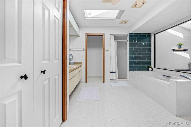 bathroom featuring vanity, shower with separate bathtub, a skylight, and tile patterned flooring