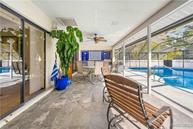 view of patio featuring a fenced in pool, ceiling fan, and glass enclosure