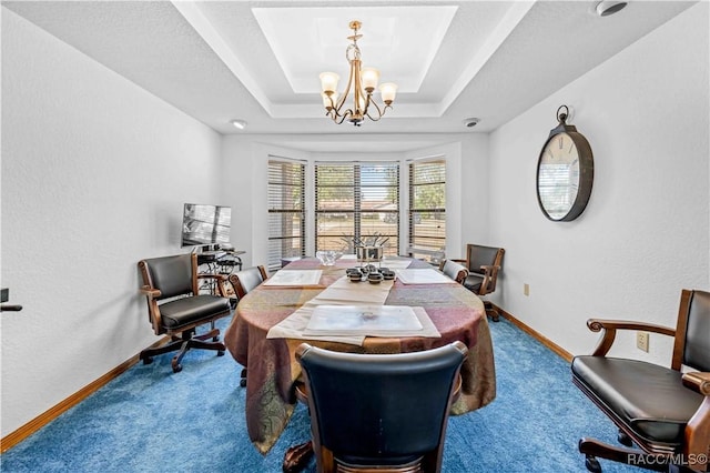 dining space featuring carpet, a notable chandelier, and a tray ceiling