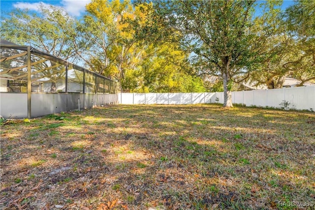 view of yard with glass enclosure