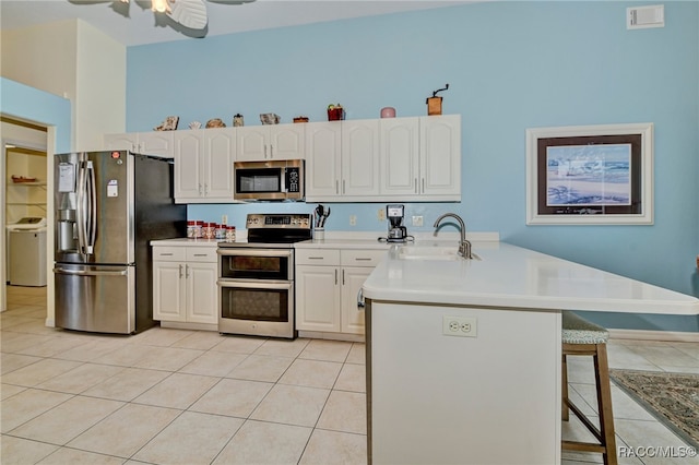 kitchen featuring kitchen peninsula, sink, white cabinets, and stainless steel appliances