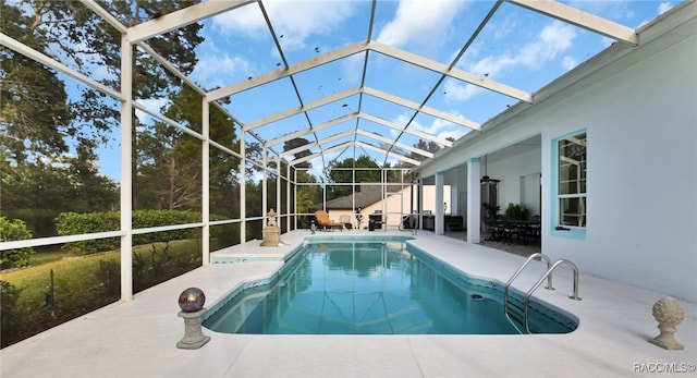 view of swimming pool with a lanai, ceiling fan, and a patio