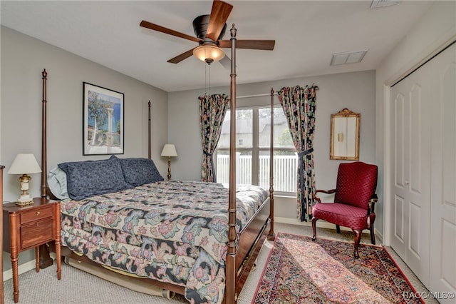 bedroom with ceiling fan, light colored carpet, and a closet