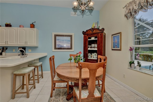 dining area with light tile patterned flooring, sink, and an inviting chandelier