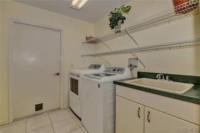 laundry area with light tile patterned flooring, sink, and washing machine and clothes dryer