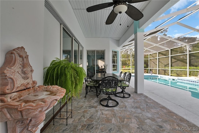 sunroom with ceiling fan, a swimming pool, and lofted ceiling