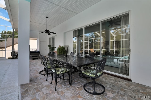 view of patio / terrace featuring ceiling fan and glass enclosure