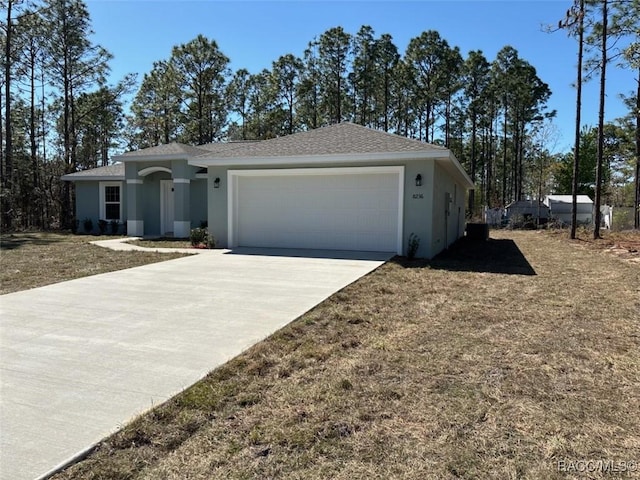 ranch-style house featuring stucco siding, an attached garage, concrete driveway, and a shingled roof