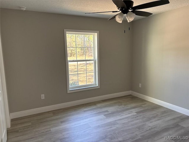 unfurnished room with wood finished floors, baseboards, and a wealth of natural light