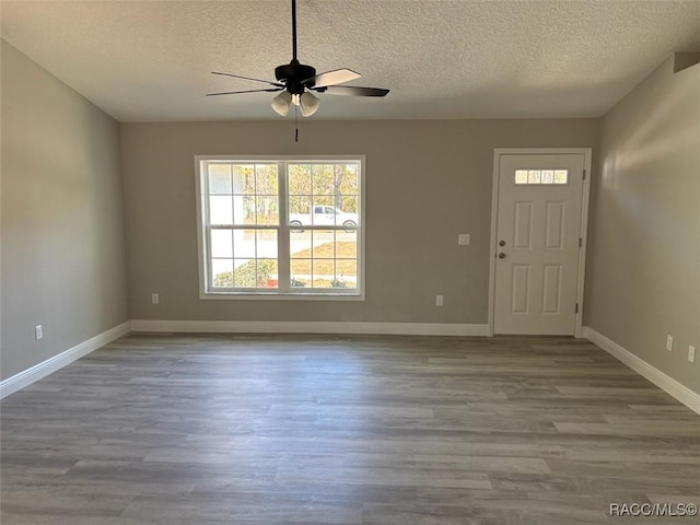 entrance foyer with baseboards, a textured ceiling, wood finished floors, and a ceiling fan