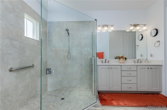 bathroom featuring hardwood / wood-style floors, vanity, and tiled shower