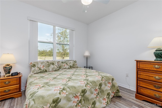 bedroom with ceiling fan, light wood-type flooring, and lofted ceiling