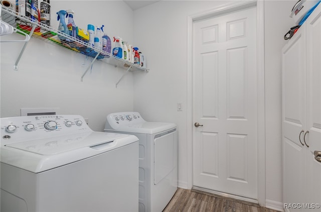 laundry room featuring wood-type flooring and washing machine and dryer