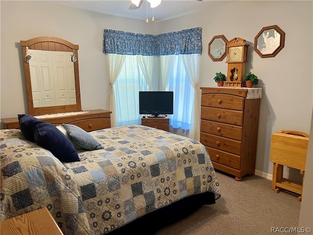 bedroom with ceiling fan, light colored carpet, and a closet