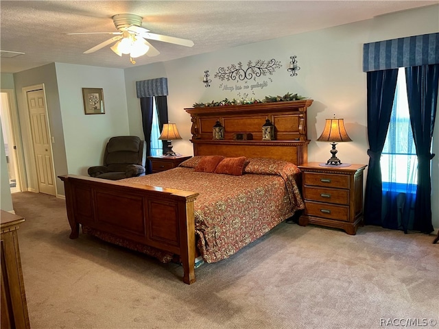 carpeted bedroom featuring ceiling fan, a textured ceiling, and a closet