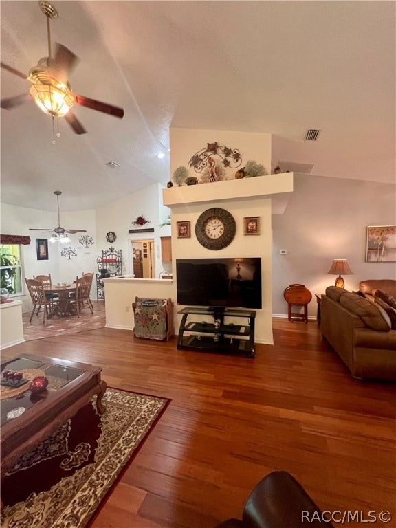 living room with hardwood / wood-style flooring, ceiling fan, and lofted ceiling