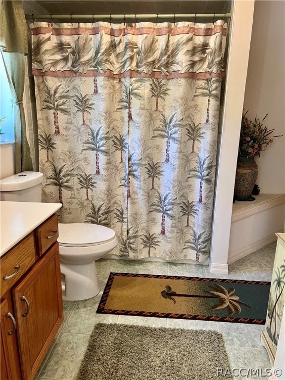 bathroom featuring curtained shower, tile patterned flooring, vanity, and toilet