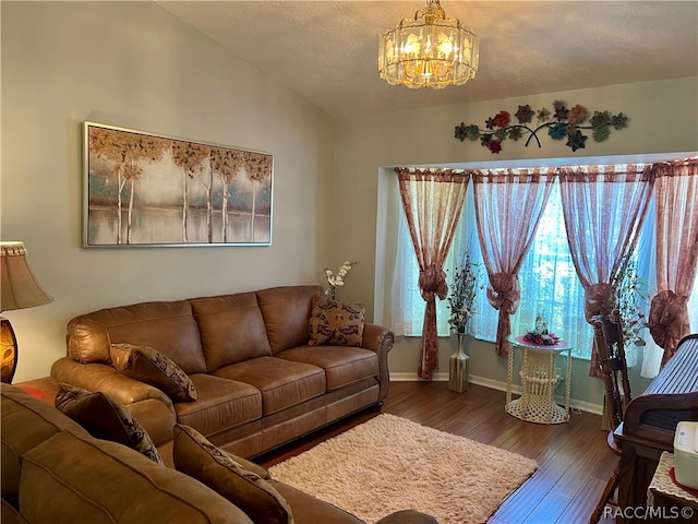 living room featuring a textured ceiling, dark hardwood / wood-style flooring, lofted ceiling, and a notable chandelier