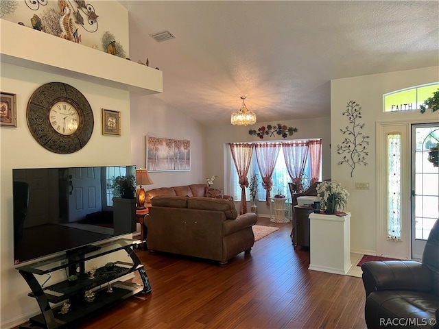 living room with a textured ceiling, dark wood-type flooring, an inviting chandelier, and lofted ceiling