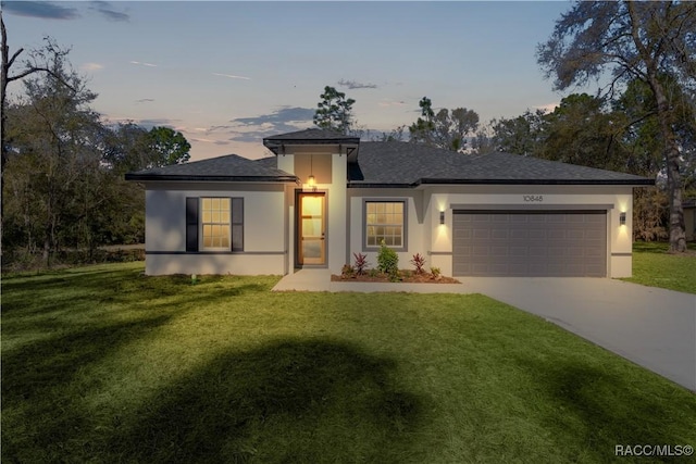 view of front of home with a front yard, an attached garage, and stucco siding