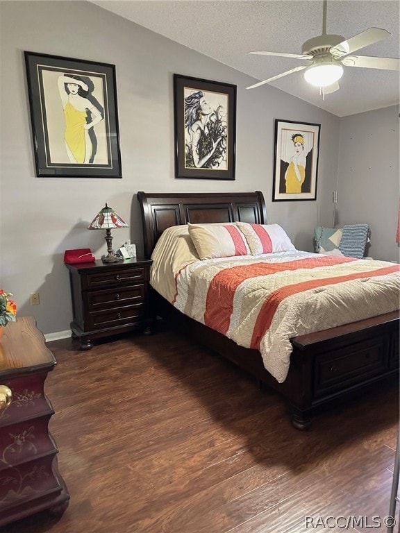 bedroom with ceiling fan, dark wood-type flooring, and vaulted ceiling