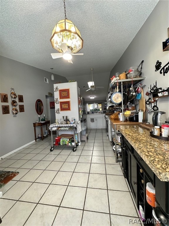 tiled dining space featuring a textured ceiling and ceiling fan