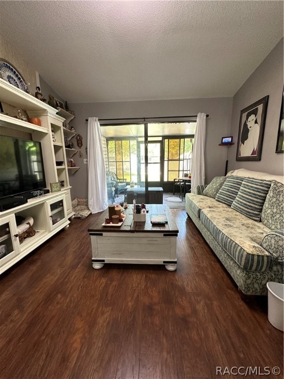 living room with dark hardwood / wood-style flooring and a textured ceiling