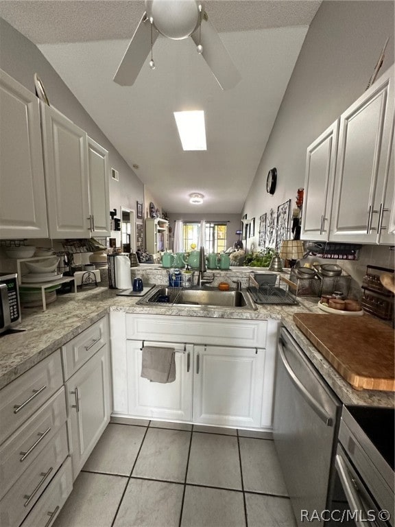 kitchen featuring kitchen peninsula, sink, dishwasher, white cabinets, and lofted ceiling