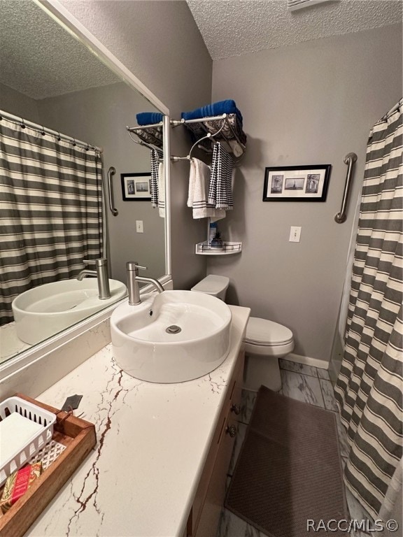 bathroom featuring vanity, toilet, and a textured ceiling