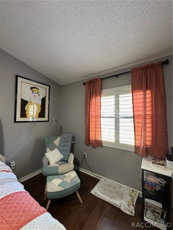 bedroom featuring a textured ceiling and dark hardwood / wood-style floors