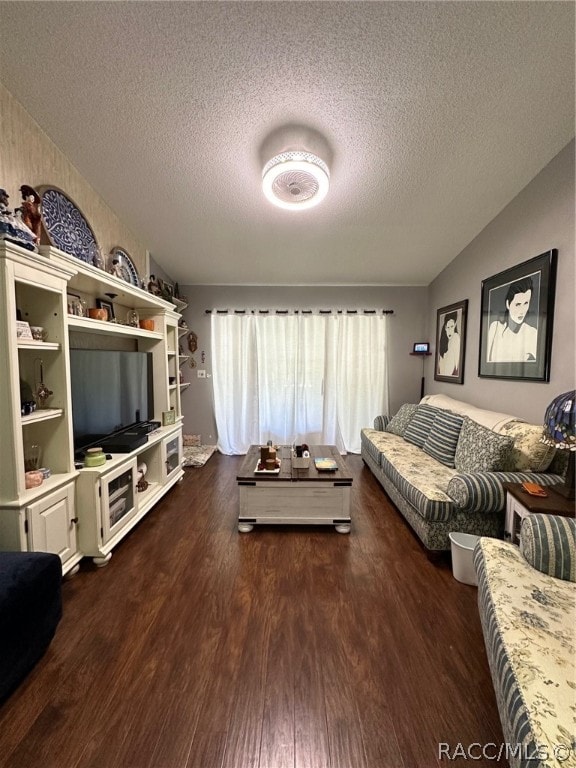 living room featuring a textured ceiling and dark wood-type flooring