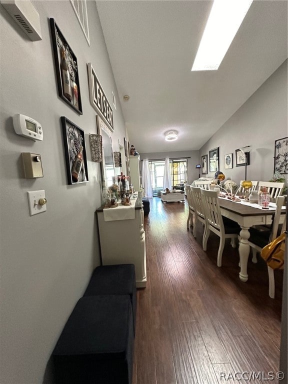 dining area featuring dark wood-type flooring and lofted ceiling