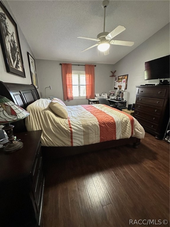 bedroom featuring ceiling fan, dark hardwood / wood-style flooring, and a textured ceiling