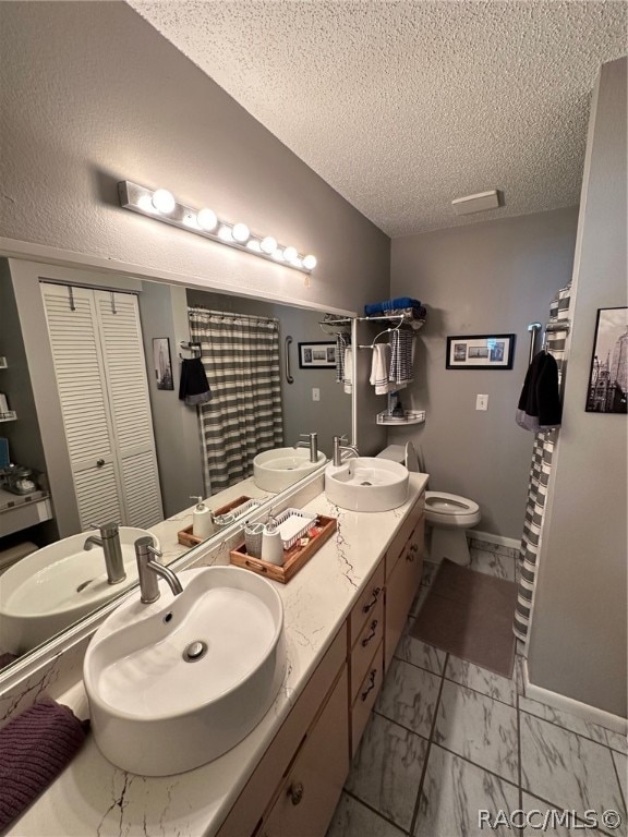 bathroom featuring vanity, toilet, and a textured ceiling