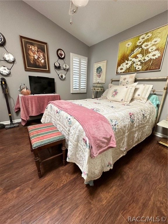 bedroom featuring dark hardwood / wood-style flooring and lofted ceiling