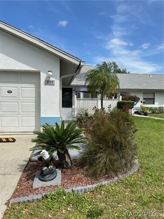 property entrance featuring a lawn and a garage