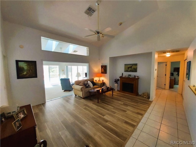 9120 SW 193rd Cir, Dunnellon, FL 34432 - living room featuring light wood-type flooring, ceiling fan, high vaulted ceiling, and a skylight
