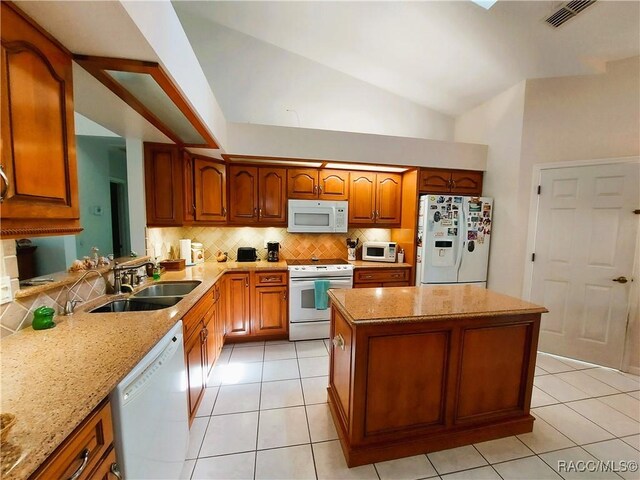 9120 SW 193rd Cir, Dunnellon, FL 34432 - kitchen with white appliances, a kitchen island, brown cabinetry, tasteful backsplash, and light tile patterned floors