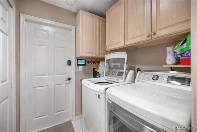 washroom with cabinets, separate washer and dryer, and light tile patterned floors