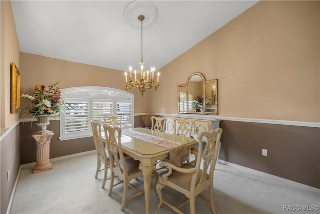 carpeted dining room with lofted ceiling and a chandelier