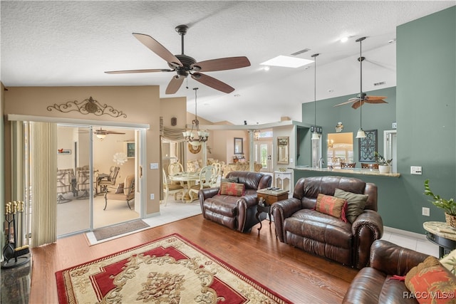 living room with ceiling fan, high vaulted ceiling, a textured ceiling, and hardwood / wood-style flooring