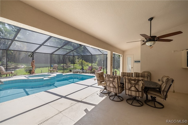 view of swimming pool featuring glass enclosure, an in ground hot tub, ceiling fan, and a patio