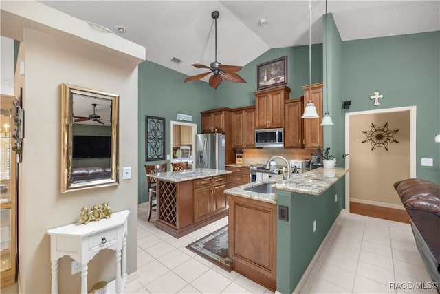 kitchen featuring sink, hanging light fixtures, high vaulted ceiling, kitchen peninsula, and appliances with stainless steel finishes