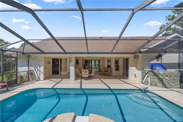 view of swimming pool with glass enclosure, ceiling fan, and a patio area