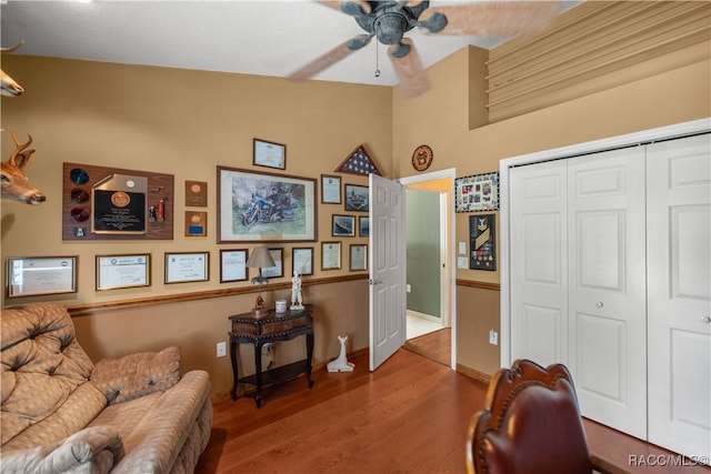 sitting room with ceiling fan, hardwood / wood-style floors, and lofted ceiling