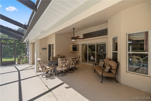 view of patio / terrace featuring an outdoor hangout area, glass enclosure, and ceiling fan